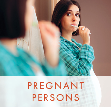 Pregnant women looking into mirror and brushing teeth