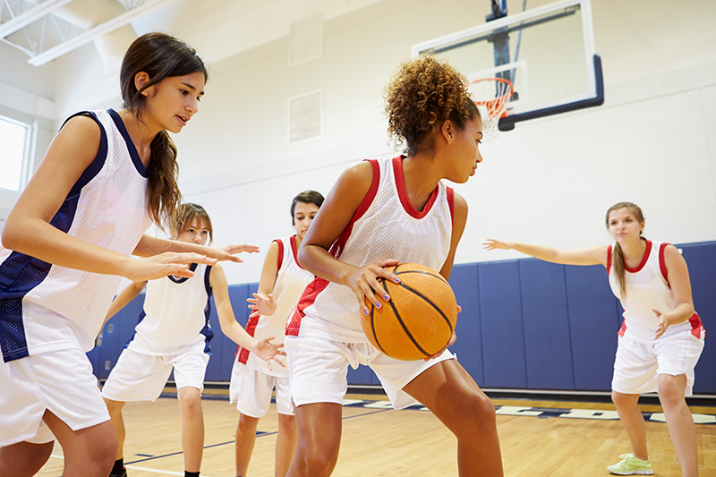 Children playing basketball in a gym