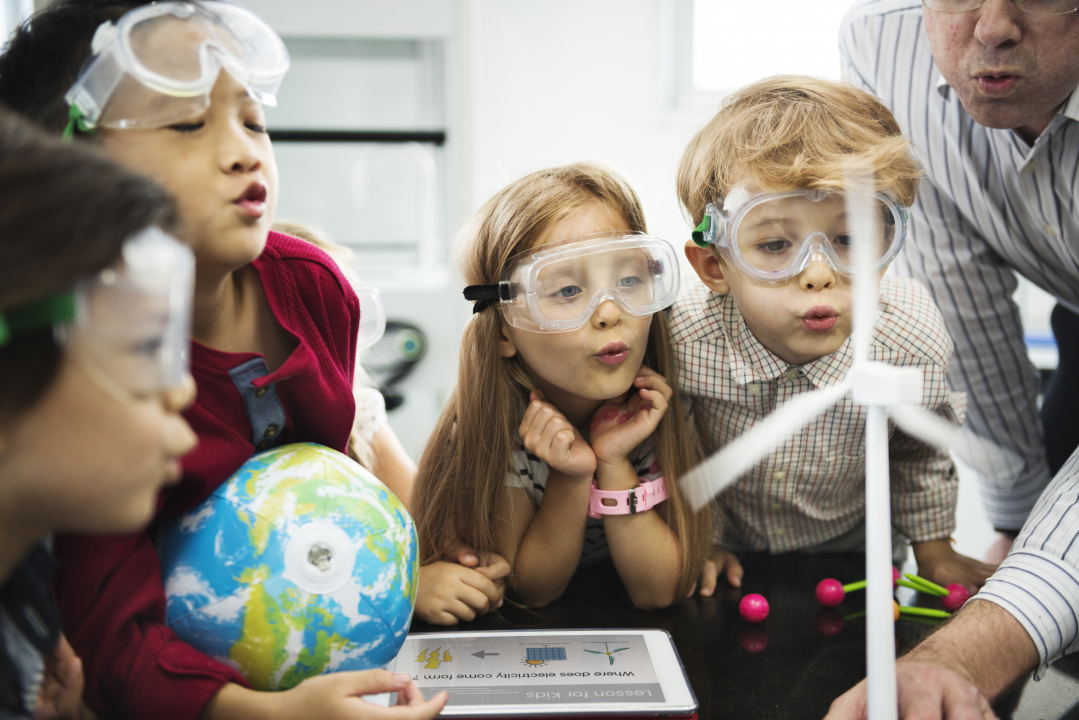 Young children doing a science experiment with teacher