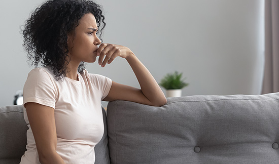 anxious-looking woman sitting on couch