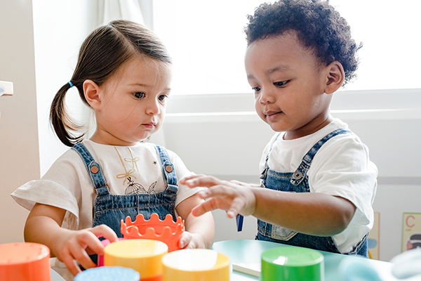 two toddlers playing with toys