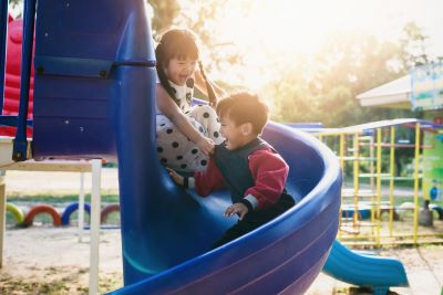 Children ride down a blue slide