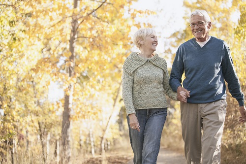 Happy older couple holding hands on a stroll