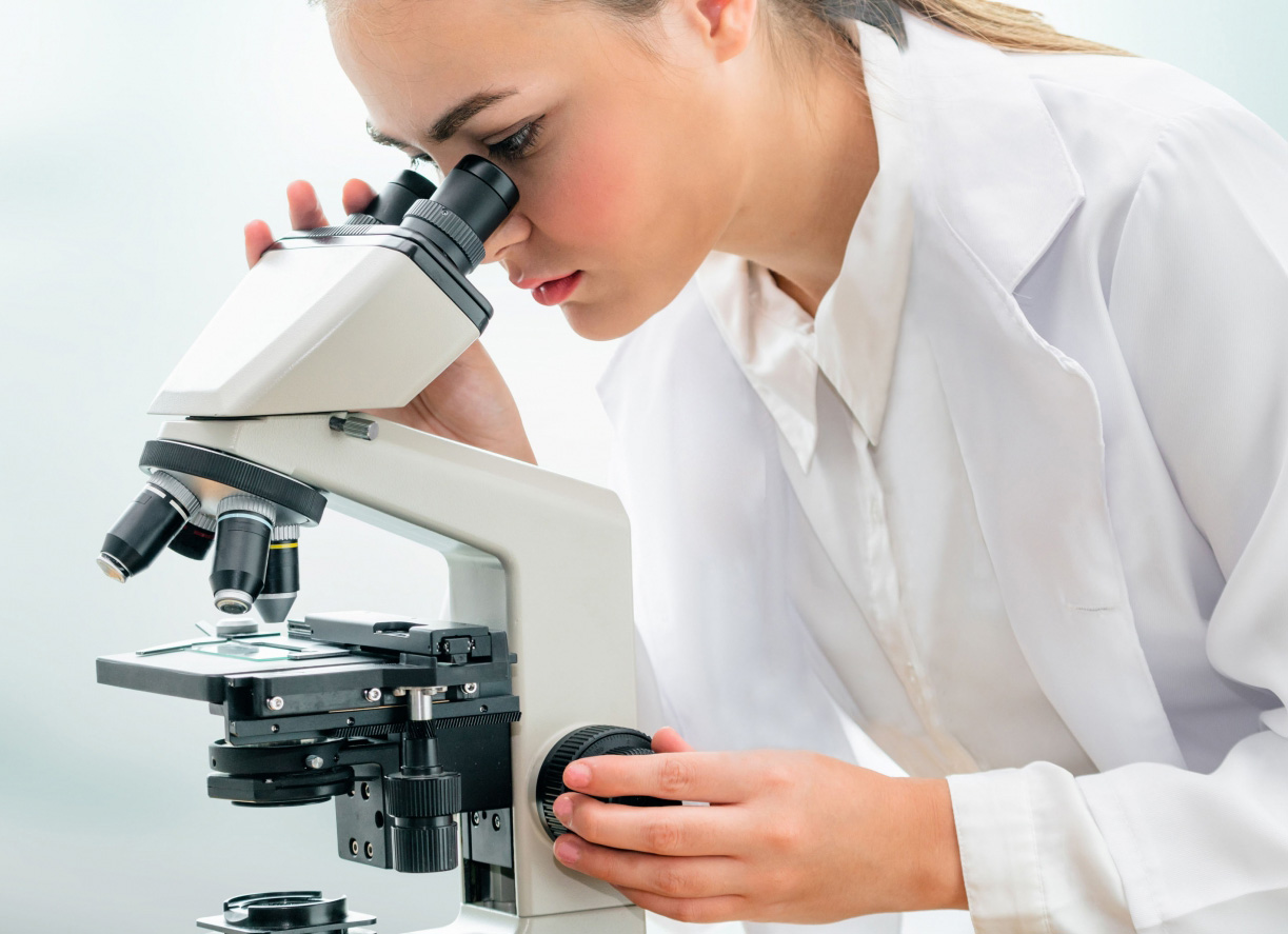 Female researcher looking under a microscope
