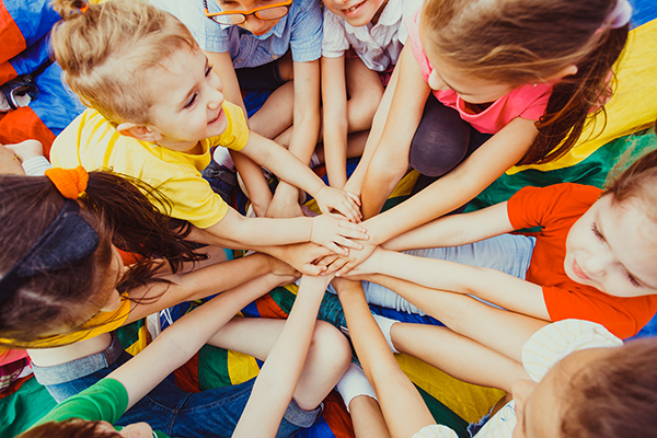 Group of children putting their hands together