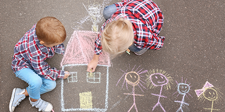 Children drawing on the sidewalk with chalk