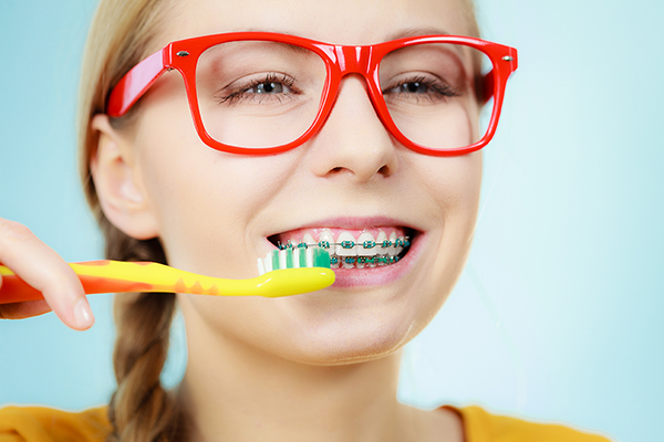 Woman with teeth braces using brush