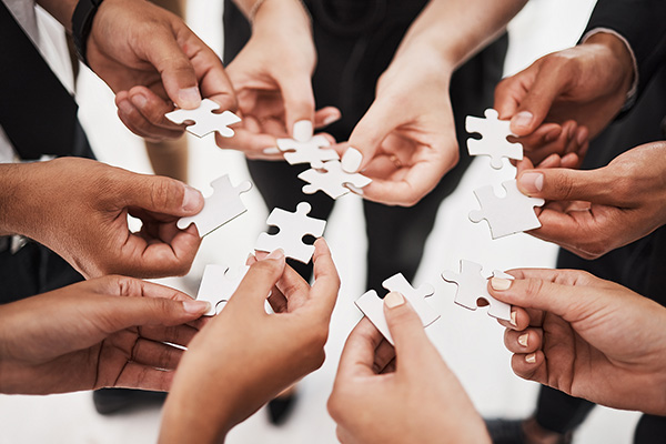 Hands, puzzle and business people collaboration, teamwork and integration closeup for planning. Team, hand and synergy with problem solving, partnership and people connecting to support innovation