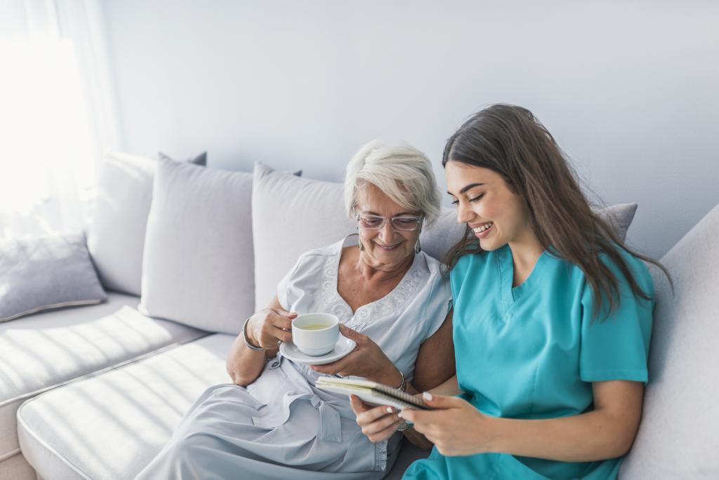Elderly and caregiver sitting on a couch