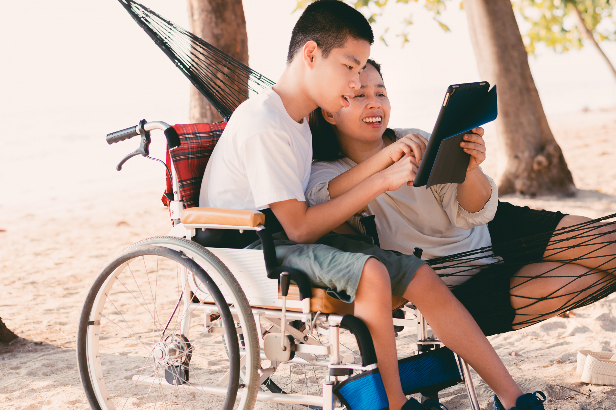 a young man in a wheelchair with another person outside