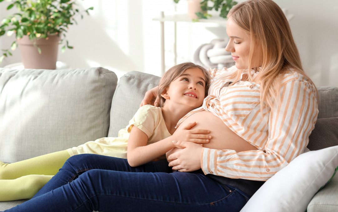 Pregnant women with a child on the couch
