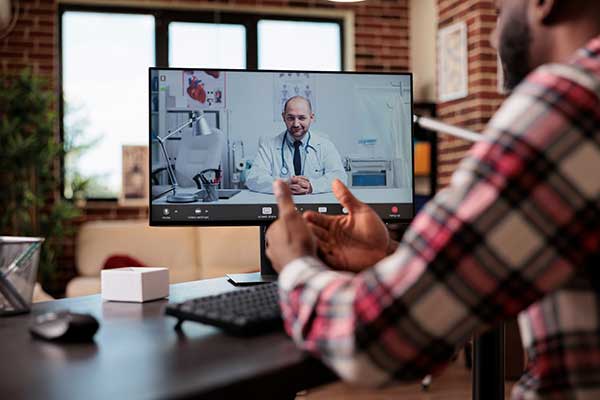 Doctor and patient talking over a computer 