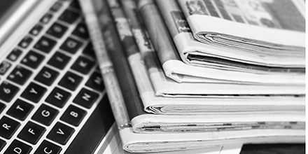 Stack of newspapers and a computer