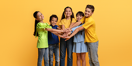 Kids putting their hands in the middle of the circle.