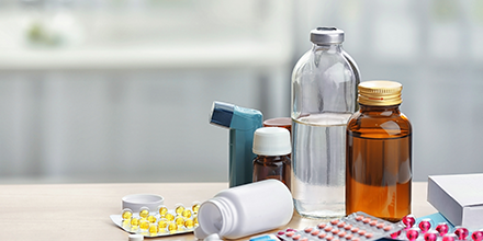 Medications, inhalers, and solutions on a table.