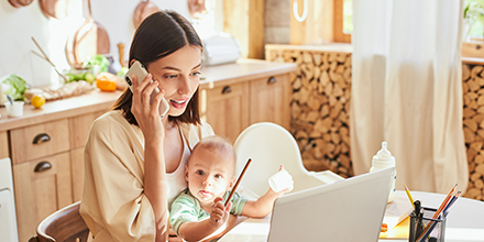 A woman making a call with her baby on her lap