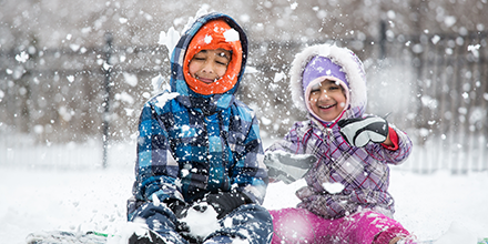 A boy and girl playing in the snow.