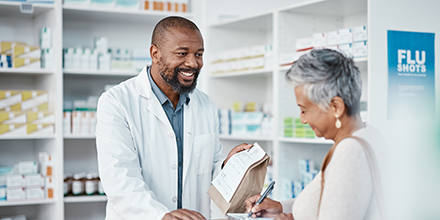 A senior woman getting her prescription from her pharmacist.