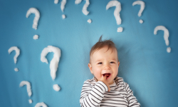 Baby on blue background with question marks