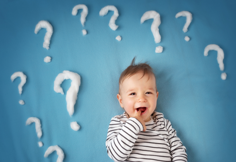 Baby on blue background with question marks
