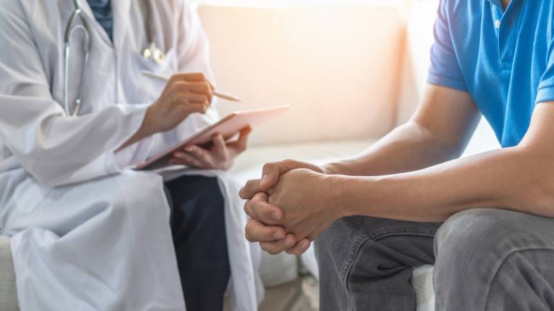 A doctor consults with her patient