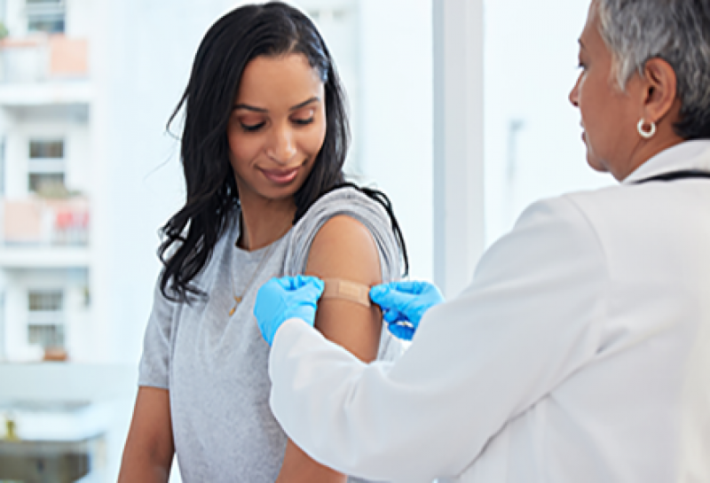 woman getting a bandage after a vaccine