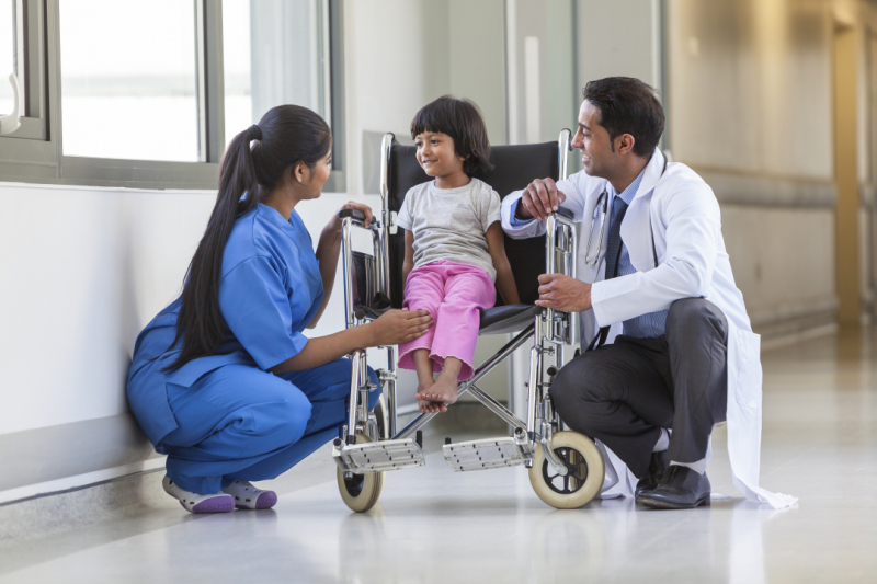 Child in wheelchair with medical providers
