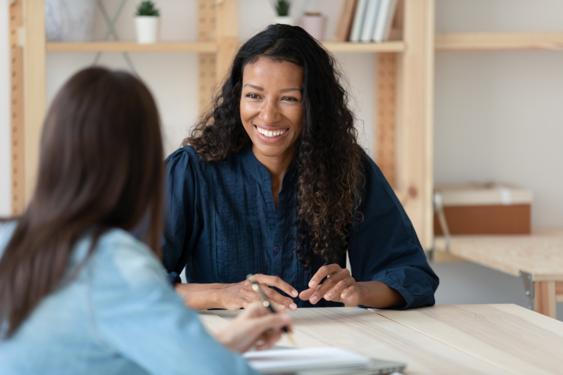 smiling woman speaks to another
