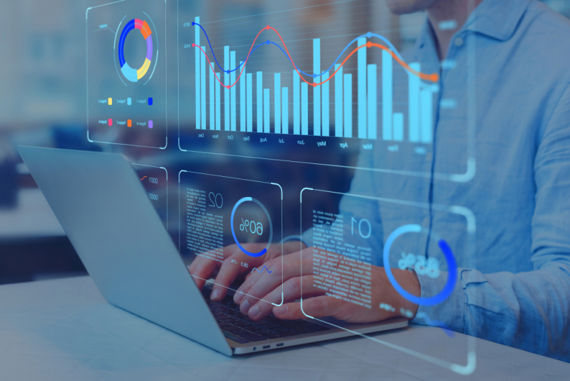 person typing on a laptop working with data charts dashboards