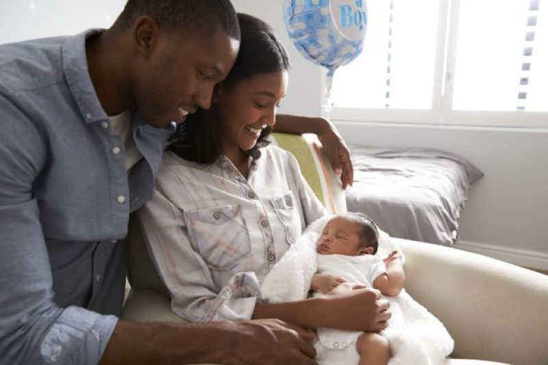 New parents cuddle their newborn